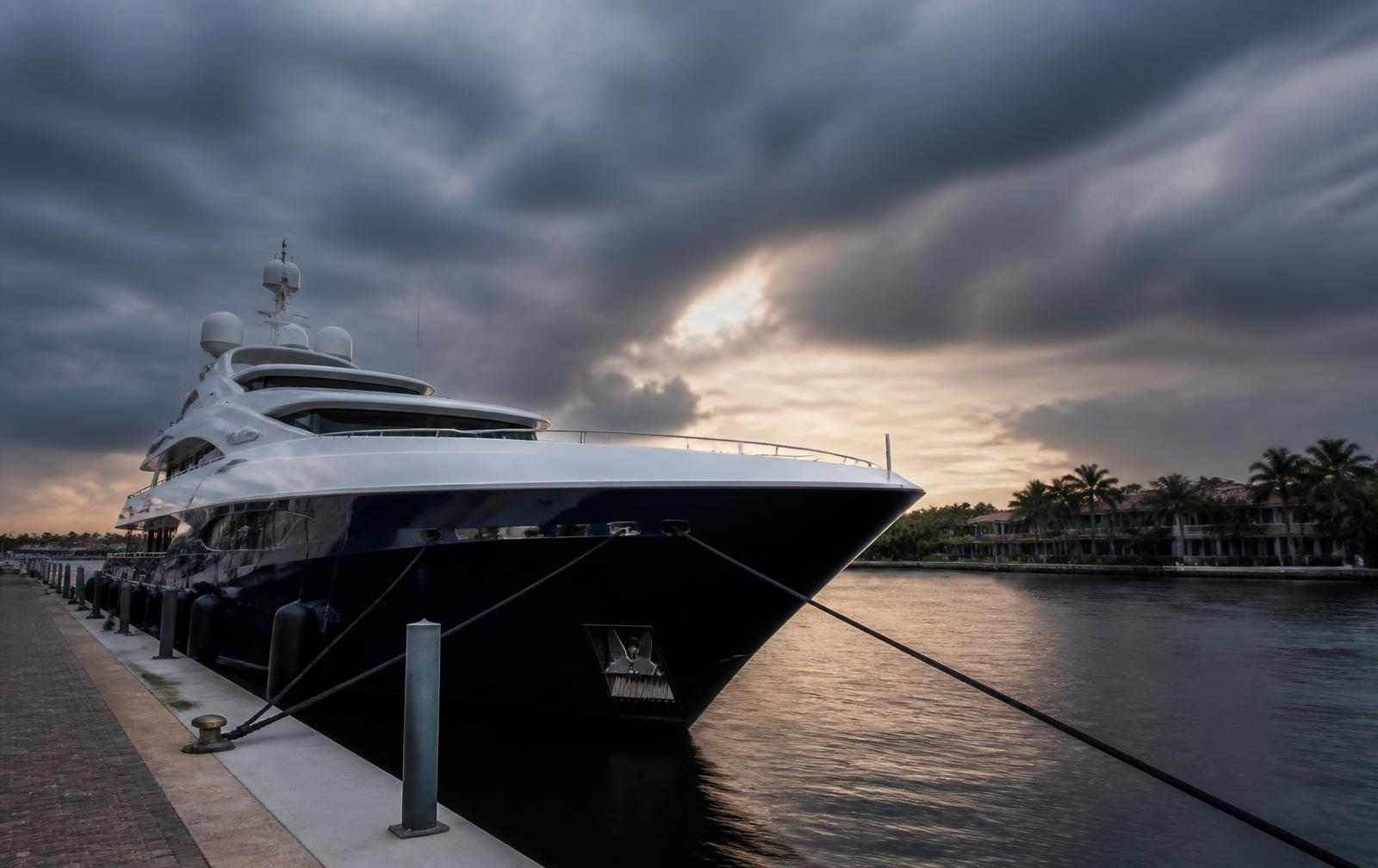 Yacht securely moored with taut dock lines as storm clouds gather over a Florida marina